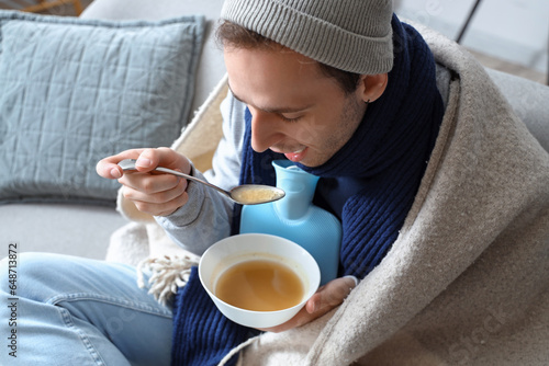 Ill young man eating soup a...