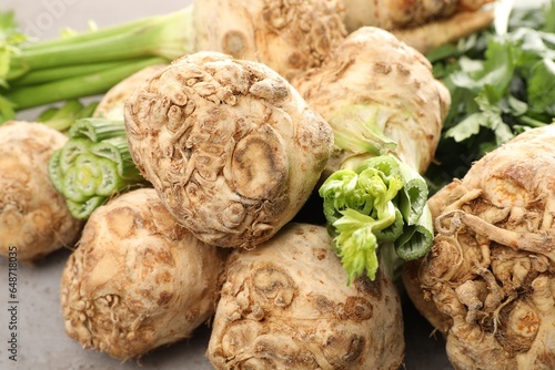 Many raw celery roots on grey table, closeup
