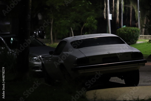 Carro clássico abandonado na estrada a noite photo