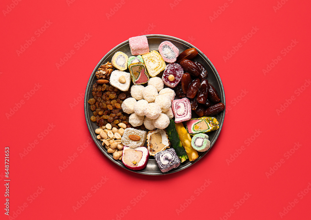 Plate with different tasty treats on red background. Divaly celebration Plate with different tasty treats on red background. Divaly celebration