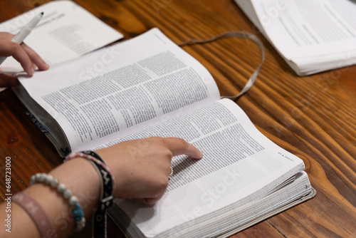 Obraz na plátně Woman reading Bible during Bible study time in a discipleship group, hands on pa