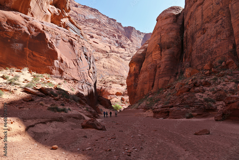 Four hikers dwarfed by the huge canyon walls of Waterholes Canyon.  This is the part of canyon accessible from the Colorado River.
