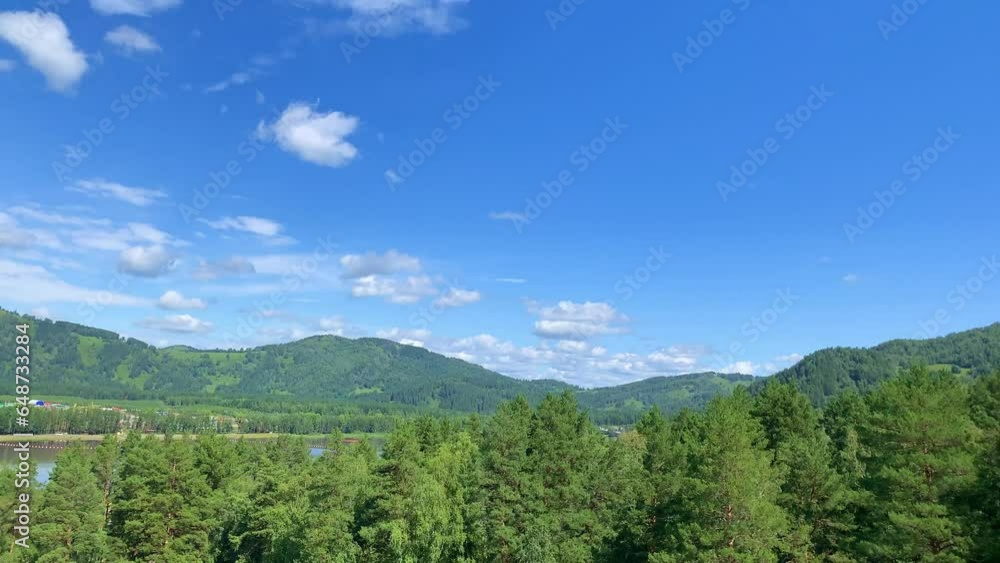 Amazing view of mountains and forest landscape with cloudy skies Altai mountains. Natural green landscapes against the background of clouds, and below the village of Manzherok, Altai Republic, Russia. Amazing view of mountains and forest landscape with cloudy skies Altai mountains. Natural green landscapes against the background of clouds, and below the village of Manzherok, Altai Republic, Russia.