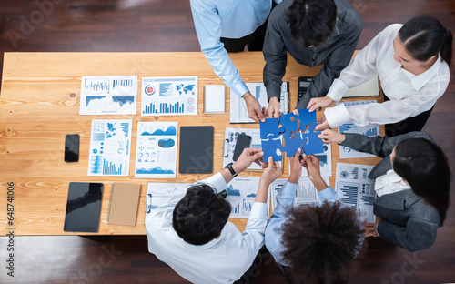 Panorama top view diverse corporate officer worker collaborate in office connect puzzle piece as partnership and teamwork concept. Unity and synergy in business success with jigsaw puzzle. Concord photo