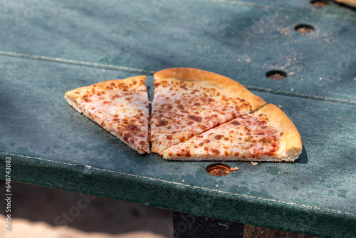 Slices of pizza on a bench.
