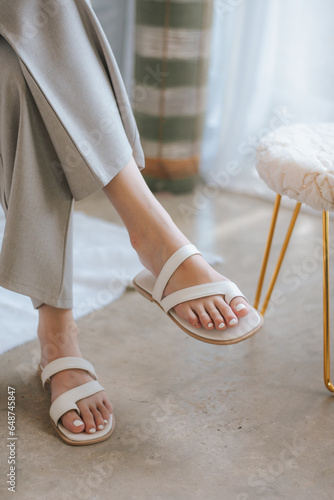 Young woman wearing grey pant and beige shoue in studio. Modern style, summer fashion trend, footwear, sandals, fashionable accessories, perfect skin, noface.