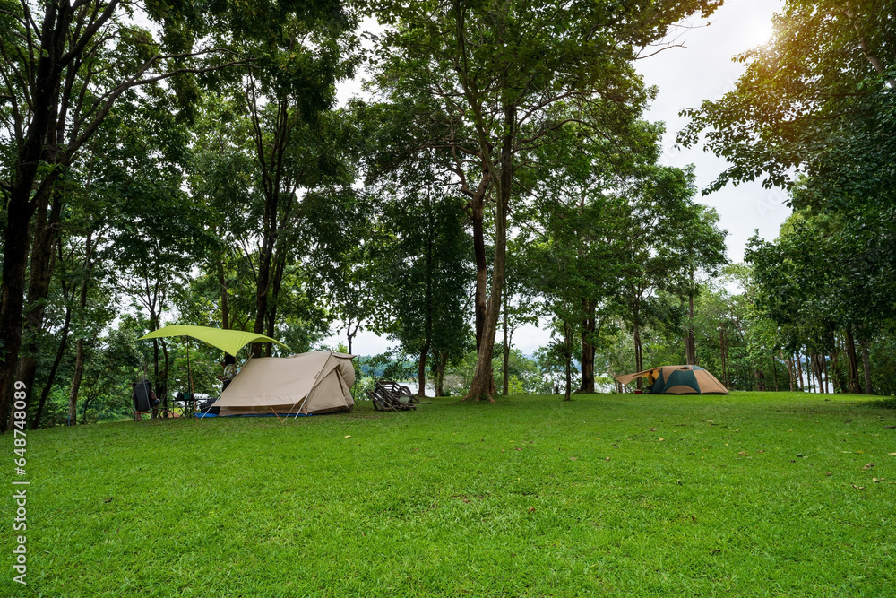 nature landscape camping or glamping cabin tent on green grass or lawn campground and tree with camper family holiday vacation on rainy season and cloudy at pom pee campsite in khao laem national park