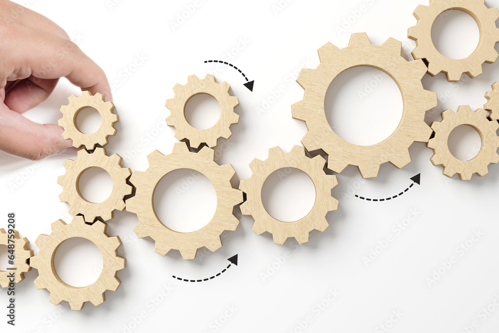 Business process and workflow automation with flowchart. Hand holding wooden cog flowing process management on white background Business process and workflow automation with flowchart. Hand holding wooden cog flowing process management on white background