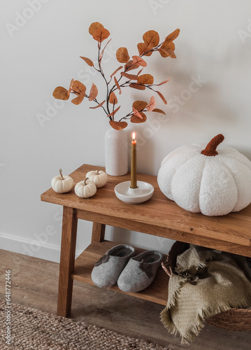 Autumn living room - oak bench with autumn decor and lit candles. Autumn mood