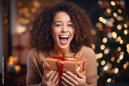 African woman smile shaking christmas present, happy female gets gift