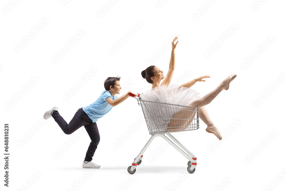 Boy pushing a ballerina inside a shopping cart Boy pushing a ballerina inside a shopping cart