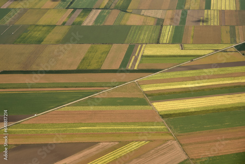 The view of the agricultural fields from the plane window. Agriculture colorful fields in the late summer. Abstract color texture background.