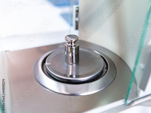 Schilderij op canvas Close-up of metal weight to calibrate on a balance in a laboratory