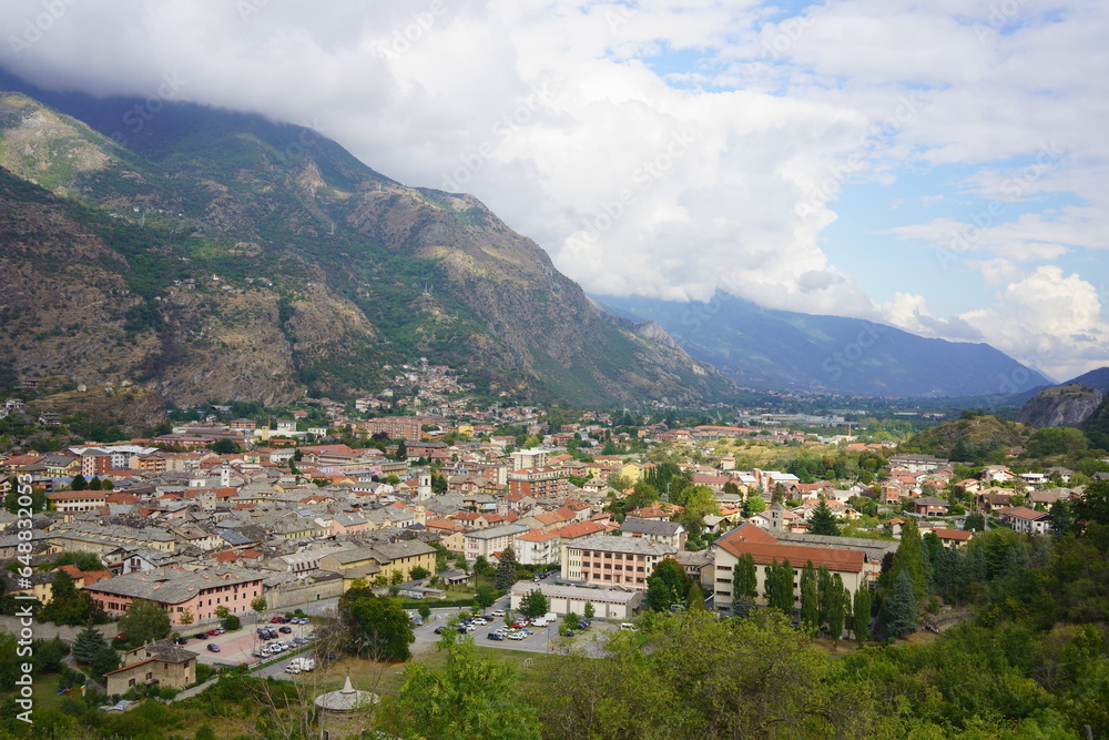 La città di Susa nelle Alpi italiane nella vallata della Valsusa in una giornata con molte nuvole e sprazzi di sole