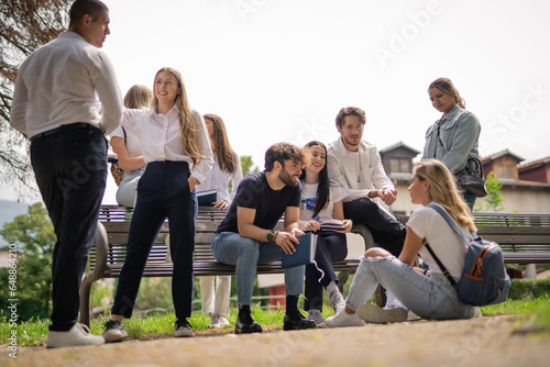 Happy, positive, smiley students relaxing at the park after exam at college