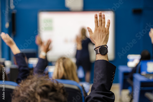 Students raising hands to answer professors question