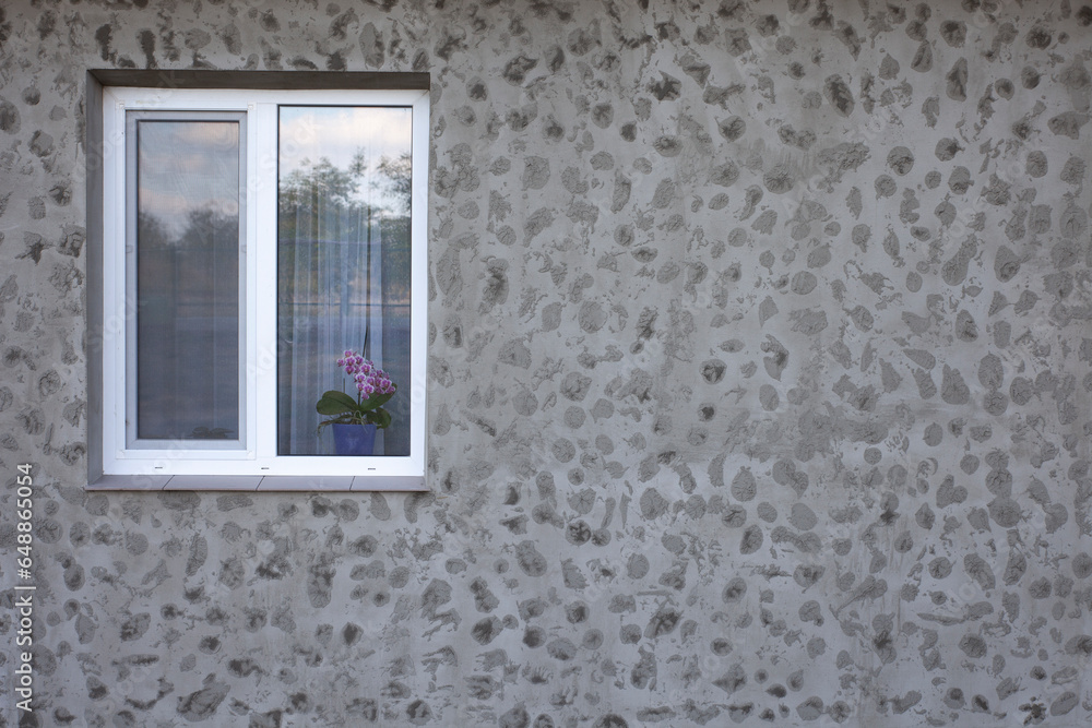 Fototapeta premium Window and gray facade of the house. Texture of fresh putty design.