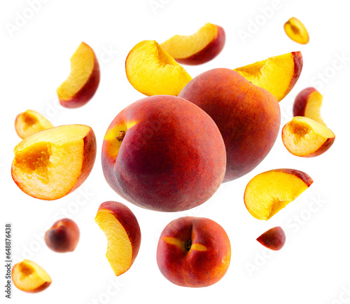 Superbly retouched whole peaches and slices fly and levitate in space. Selective focus. Isolated on white