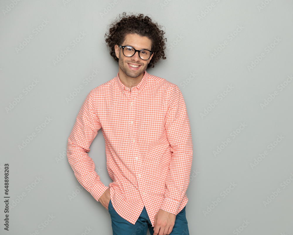 happy casual man with glasses holding hand in pockets and smiling happy casual man with glasses holding hand in pockets and smiling