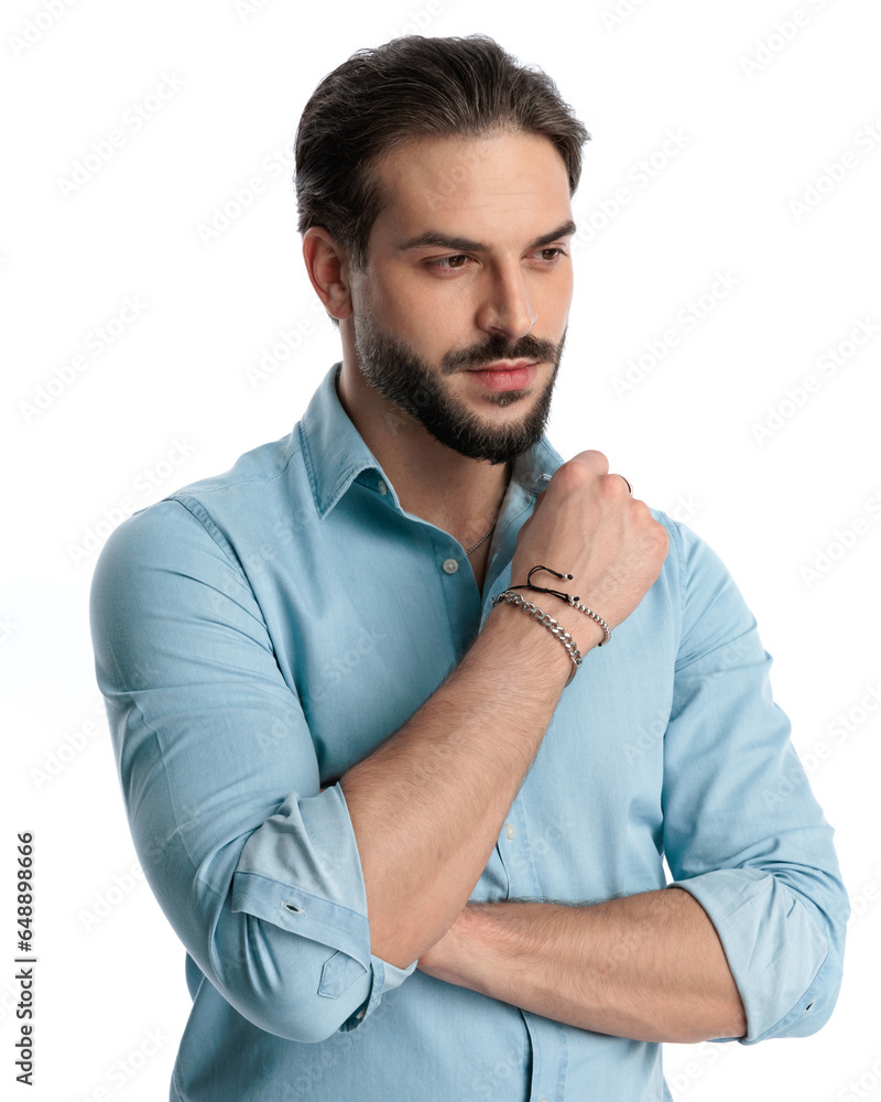 Obraz premium thoughtful young man with beard in denim shirt looking away