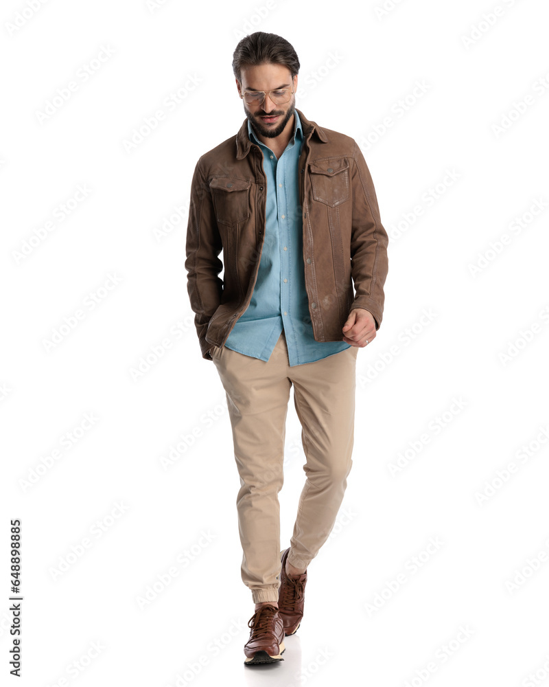 happy casual man with glasses walking with hand in pocket and smiling happy casual man with glasses walking with hand in pocket and smiling