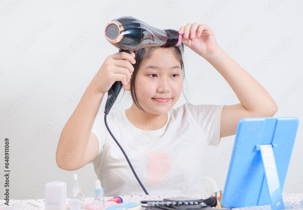 cute girl wearing hair rollers and holds a hair dryer and look at the mirror isolated on white cute girl wearing hair rollers and holds a hair dryer and look at the mirror isolated on white