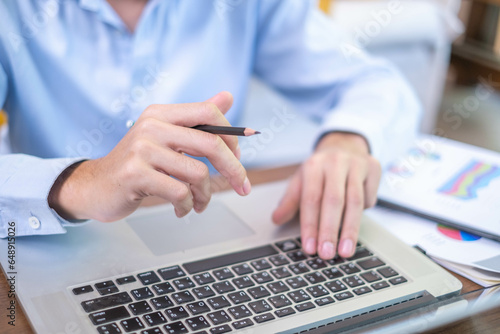 Close-up freelance businessman working at indoors home office typing hand on desk computer laptop internet communication technology, human hand adult business person using laptop keyboard notebook