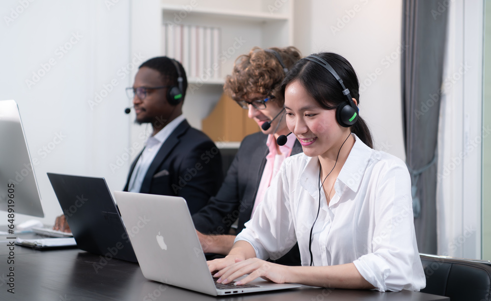 Group of business people wearing headset working actively in office. Call center, telemarketing, customer support agent provide service on telephone video conference call. Group of business people wearing headset working actively in office. Call center, telemarketing, customer support agent provide service on telephone video conference call.