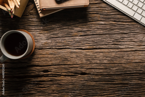 Simple workplace with eyeglasses, notebooks, keyboard and coffee cup. Top view with copy space.