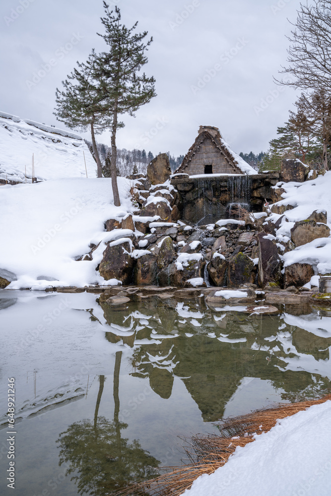 he image of a snow-covered thatched roof cottage is perfectly mirrored, creating a mesmerizing symmetry. he image of a snow-covered thatched roof cottage is perfectly mirrored, creating a mesmerizing symmetry.