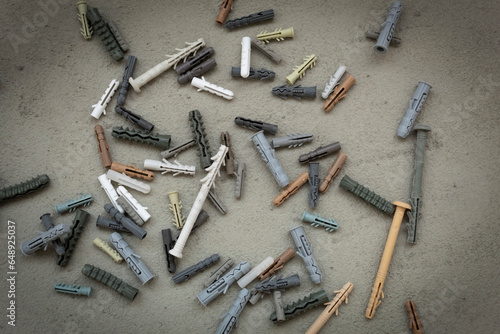 Plastic dowels scattered randomly on a concrete surface. The working process. Consumables for repairs. photo