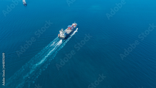 Stern of large cargo ship import export container box on the ocean sea on blue sky back ground concept transportation logistic and service to customer and supply change.