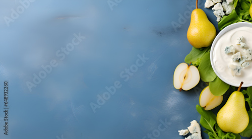 Pear and blue cheese banner with copy space. Whole and halfed pears and pices of blue cheese on light blue concrete background. Healthy eating concept. Vegetarian snacks photo