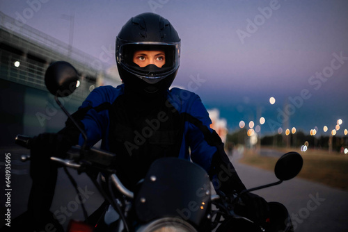 Valokuva Female motorcyclist in a helmet and motorcycle jacket close-up