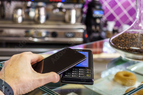 Contactless payment by smartphone. Payment with NFC technology in a payment terminal of a cafeteria. tpv.