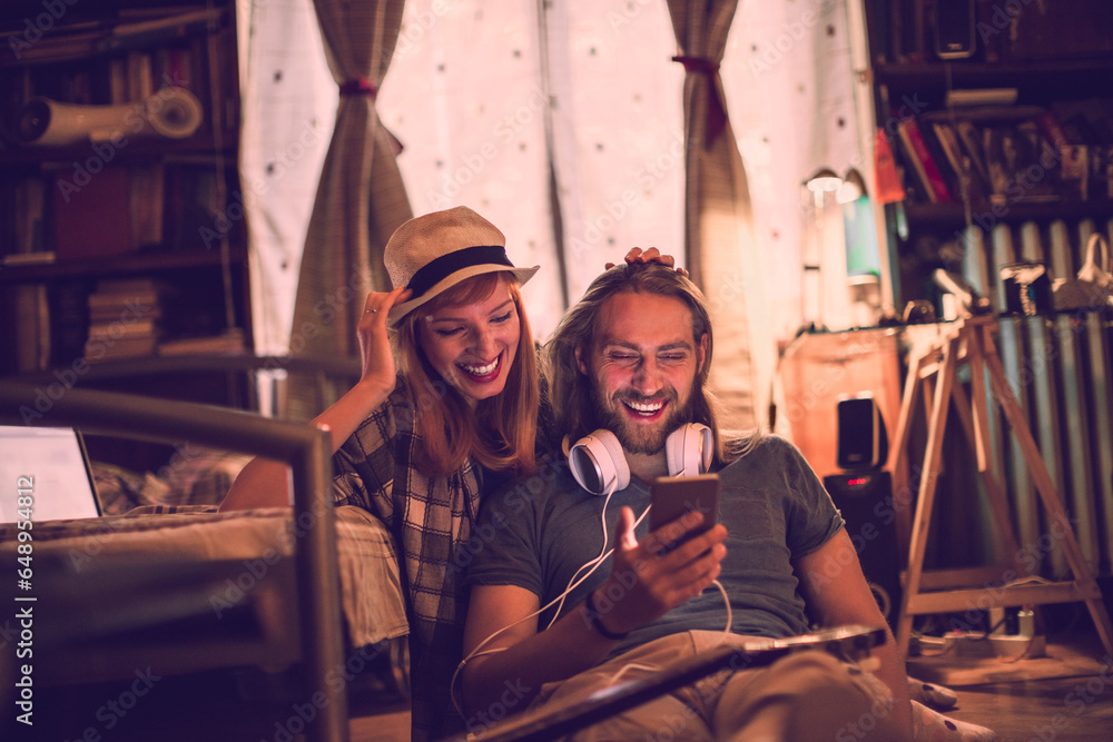 Young couple using a smartphone in the bedroom at home Young couple using a smartphone in the bedroom at home