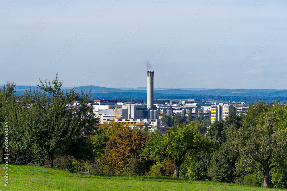 Scenic view of rural landscape with meadow and orchard with skyline of City of Zürich North in the background on a sunny late summer afternoon. Photo taken September 17th, 2023, Zurich, Switzerland.