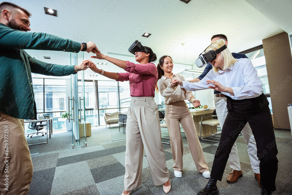 © Mediteraneo - Group of professional people playing with VR glasses on the work in the modern office.Team Building