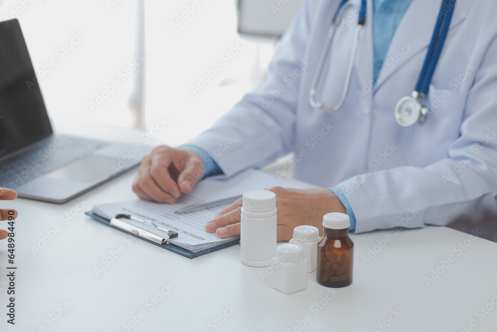 Lets set up an appointment for next week. Cropped shot of a young male doctor going through medical records with his senior male patient. Lets set up an appointment for next week. Cropped shot of a young male doctor going through medical records with his senior male patient.