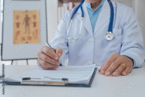 Lets set up an appointment for next week. Cropped shot of a young male doctor going through medical records with his senior male patient.