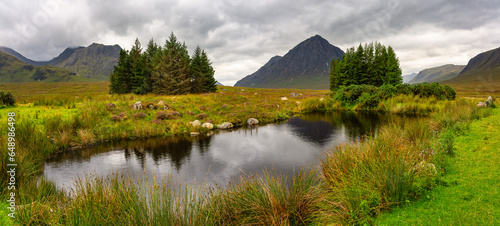 Beautiful panoramic landscape of high mountains  trees and lakes in the Glencoe Valley  Scotland.