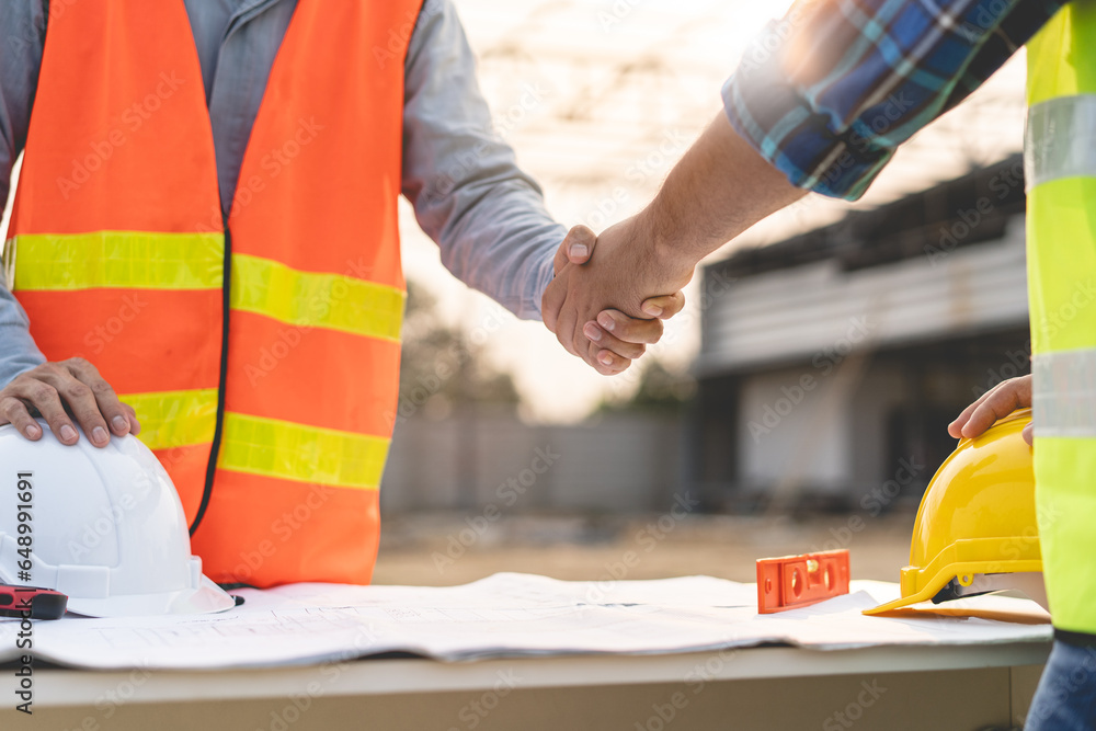 construction worker and contractor. Client shaking hands with team builder in the factory construction site. construction worker and contractor. Client shaking hands with team builder in the factory construction site.