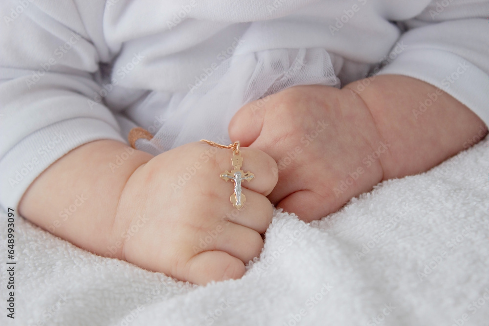 hand of a child with a cross, baptism of a child. hand of a child with a cross, baptism of a child.