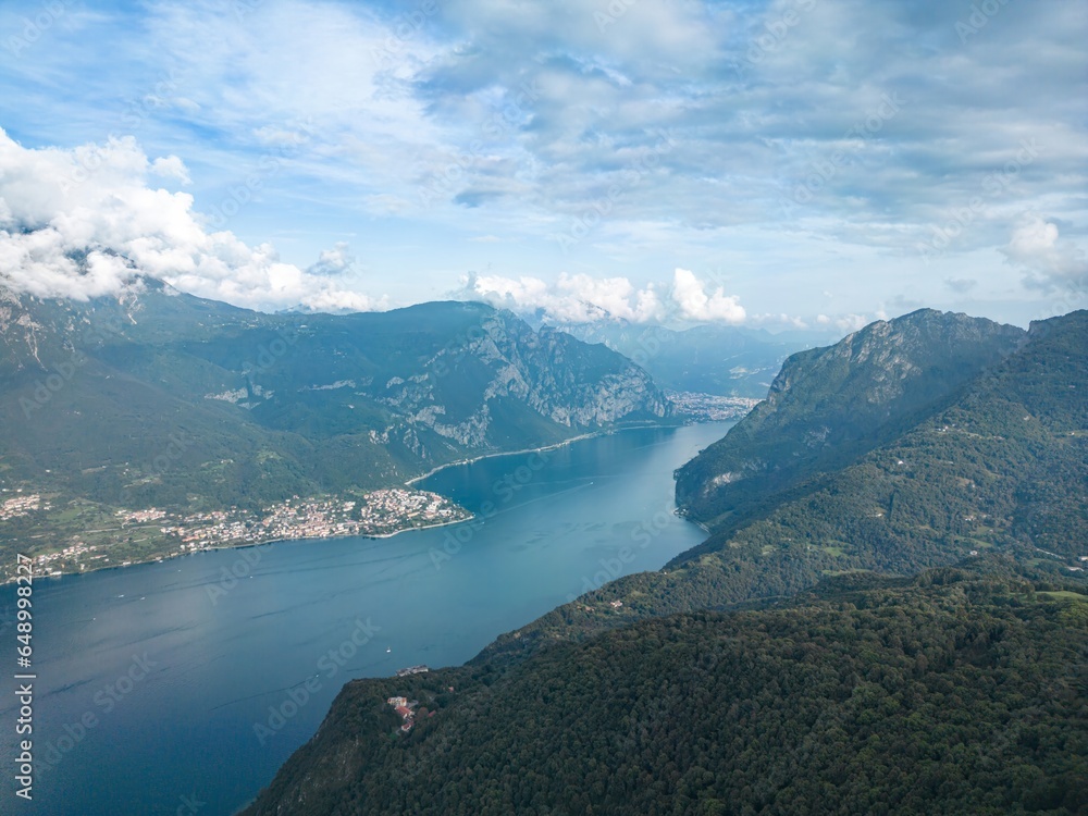 Lake Como's beauty captured aerially near Lecco. Mountains and gentle clouds complement the tranquil scene