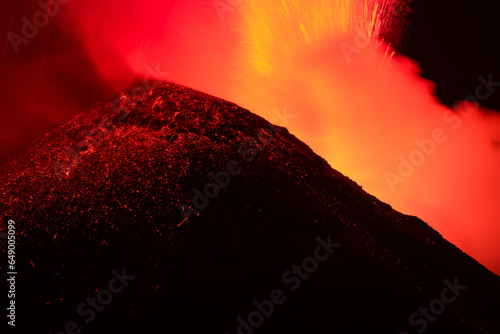 Etna - Esplosione di lava dal cratere durante l'eruzione vulcanica di notte con sfondo nero photo