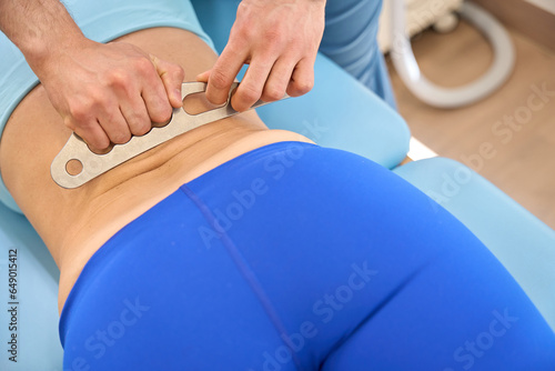 Registered massage therapist using instrument assisted soft tissue mobilization photo