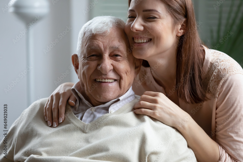 Portrait of loving grownup millennial girl hug show care and gratitude to senior 80s father, enjoy family weekend at home together, happy elderly dad and adult daughter embrace, bonding concept Portrait of loving grownup millennial girl hug show care and gratitude to senior 80s father, enjoy family weekend at home together, happy elderly dad and adult daughter embrace, bonding concept