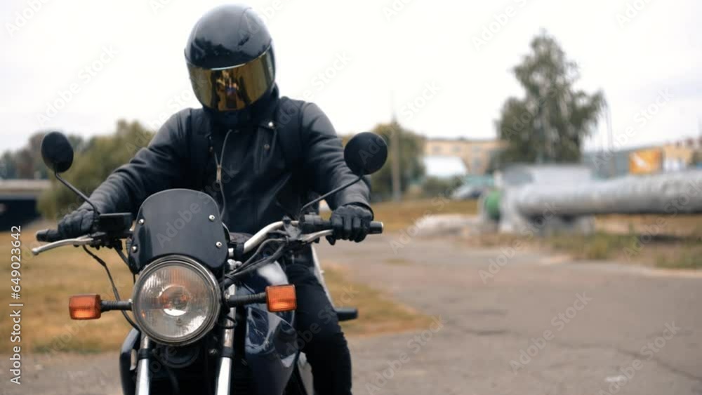 motorcyclist in a leather jacket and helmet with sun protection glass on a classic motorcycle. motorcyclist in a leather jacket and helmet with sun protection glass on a classic motorcycle.