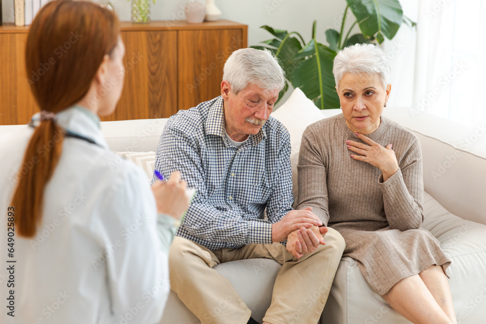 Female doctor examining older senior couple in doctor office or at home. Old woman man patient and doctor have consultation in hospital room. Medicine healthcare medical checkup. Visit to doctor Female doctor examining older senior couple in doctor office or at home. Old woman man patient and doctor have consultation in hospital room. Medicine healthcare medical checkup. Visit to doctor