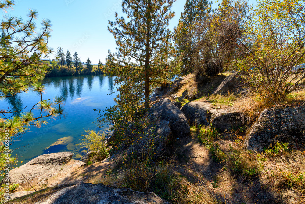 The rocky hilly riverbank along the shores of the Spokane River at the public Boulder Beach Park in Spokane, Washington USA at summer. The rocky hilly riverbank along the shores of the Spokane River at the public Boulder Beach Park in Spokane, Washington USA at summer.